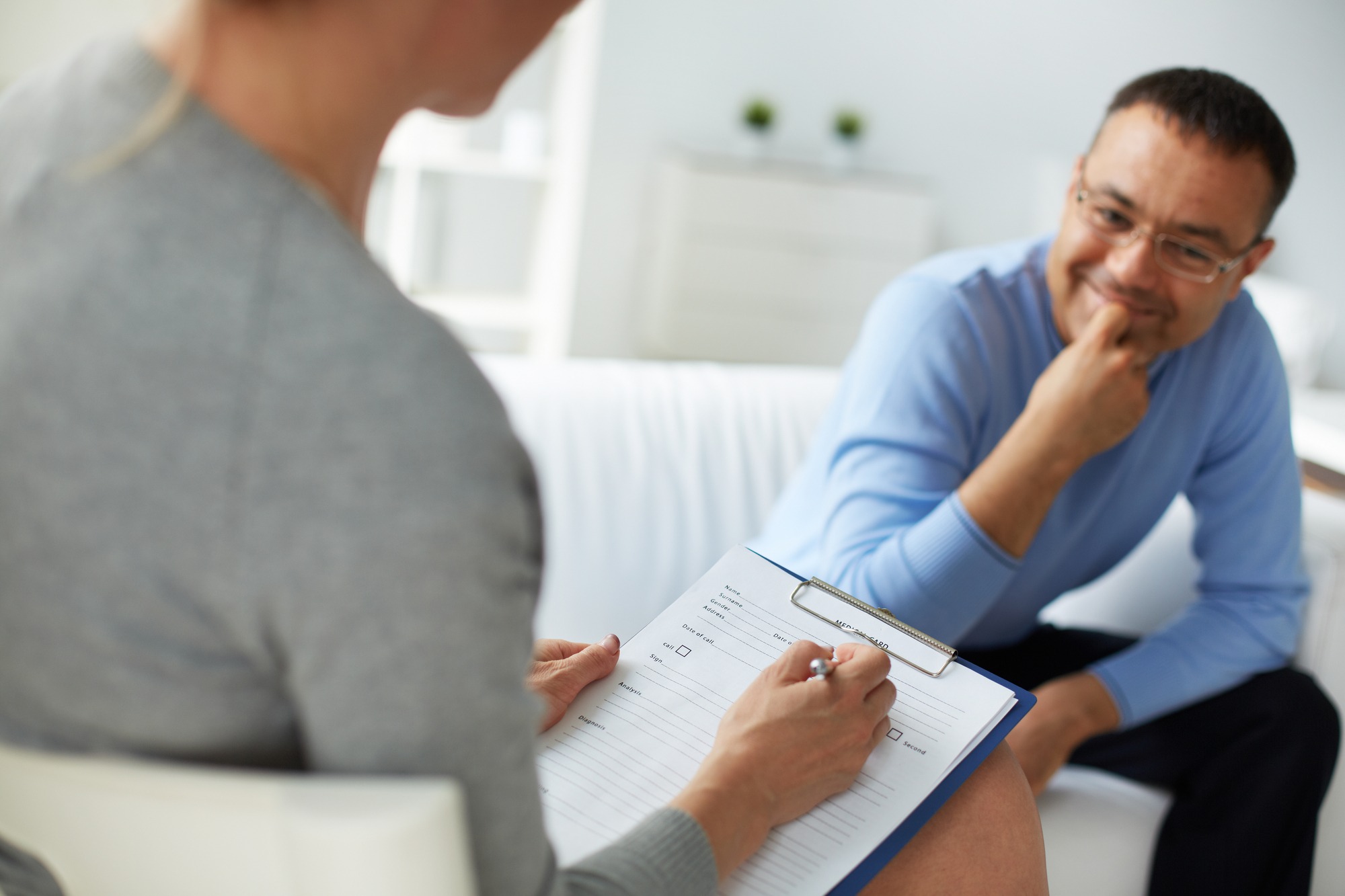 Female psychologist consulting man during psychological therapy session